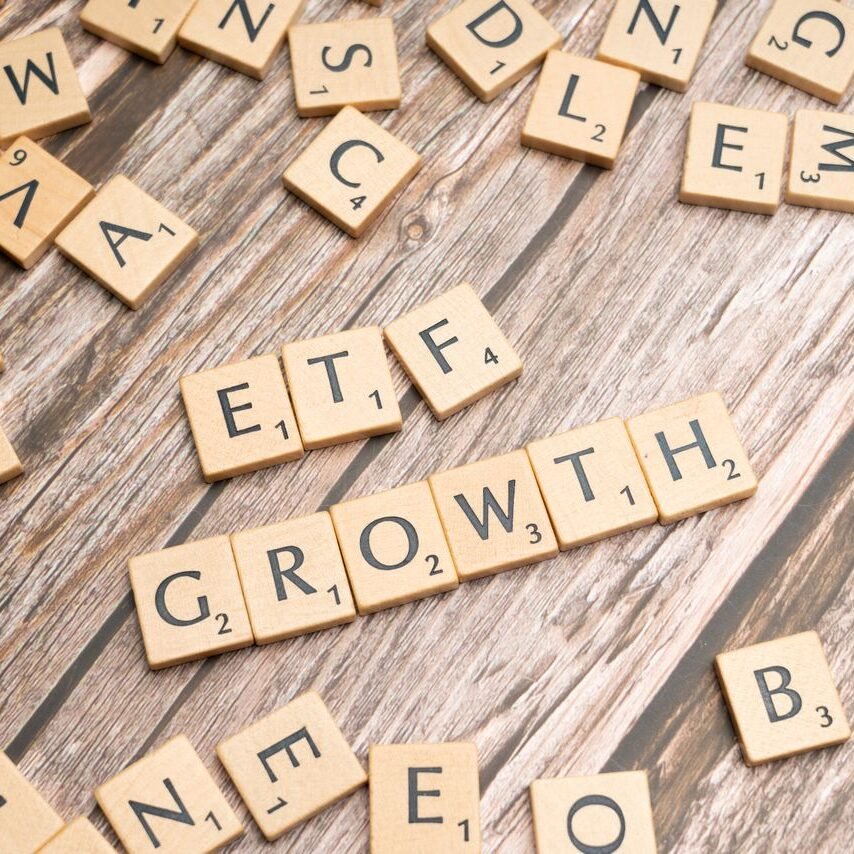 Investment Opportunity in noida Wooden tiles spelling ETF growth on a wooden surface, symbolizing investment strategy.