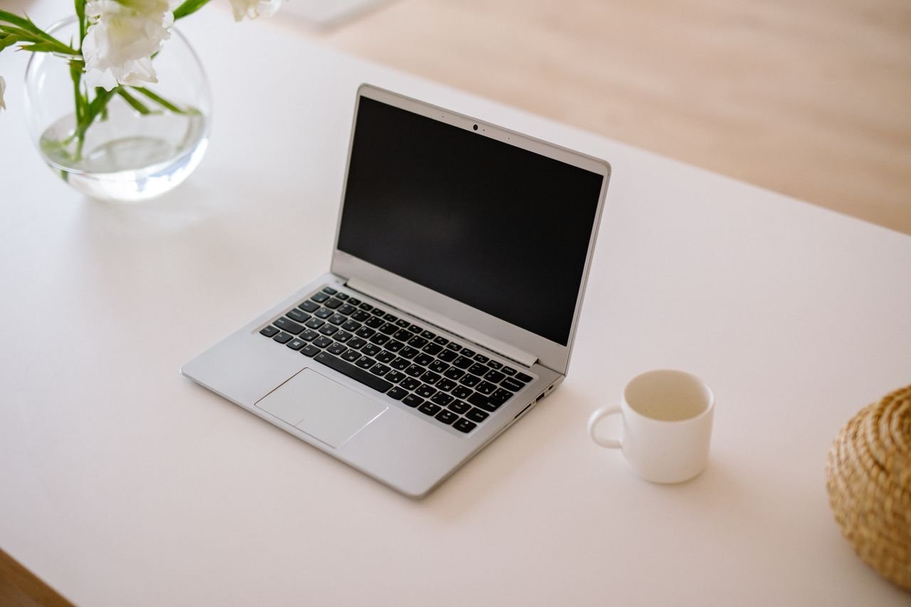 pexels photo 5793947 5793947 A minimalist workspace with an open laptop, coffee mug, and vase on a bright indoor table.